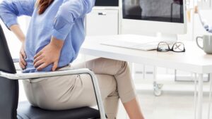 Empleado con una posición poco ergonómica al trabajar en su escritorio frente al ordenador